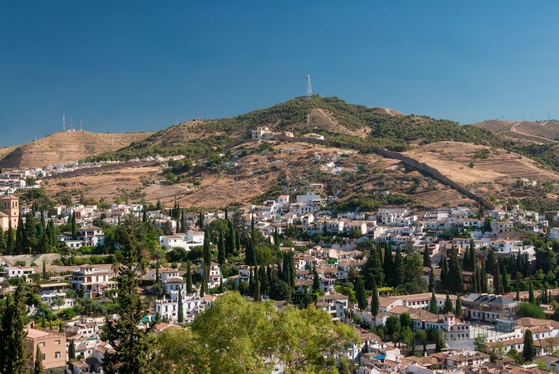 un pequeño pueblo está rodeado de montañas y árboles