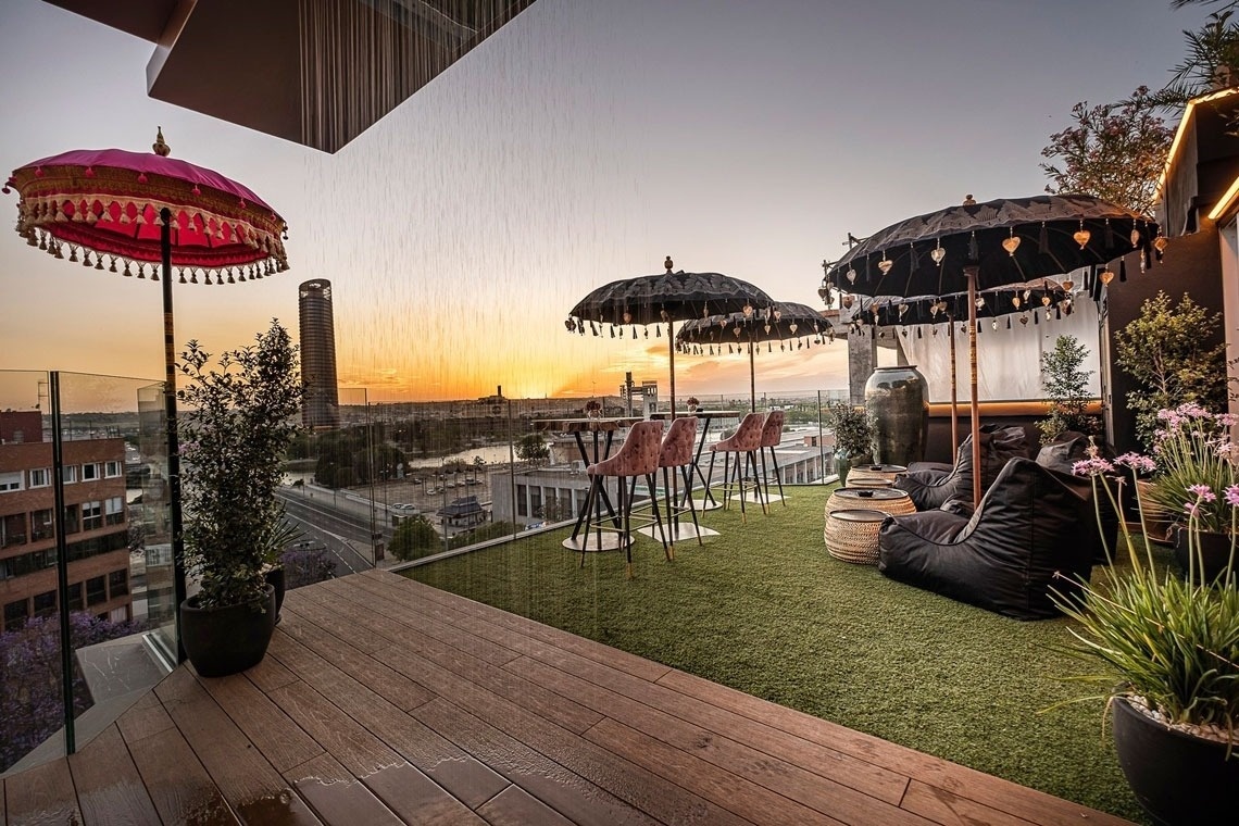 a balcony with a view of a city at sunset