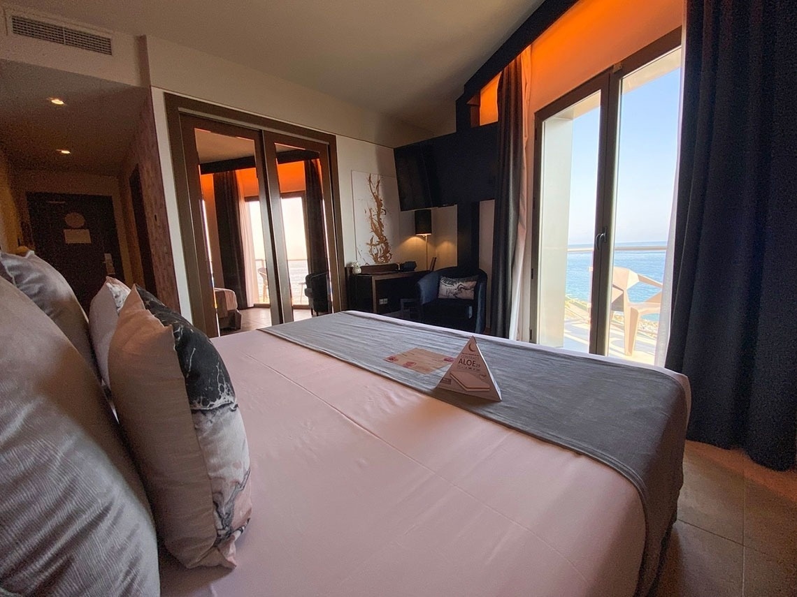a hotel room with a king size bed and a view of the ocean