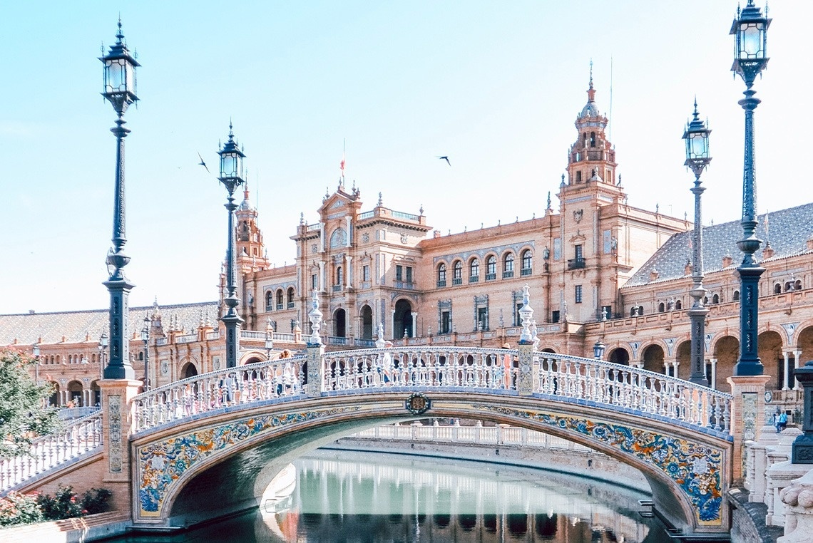 eine Brücke über einen Fluss mit einem großen Gebäude im Hintergrund