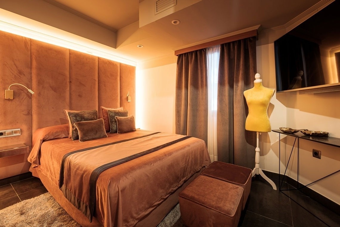 a bedroom with a large bed and a yellow mannequin