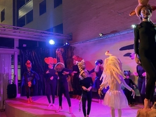 un grupo de personas con disfraces de animales están bailando en un escenario