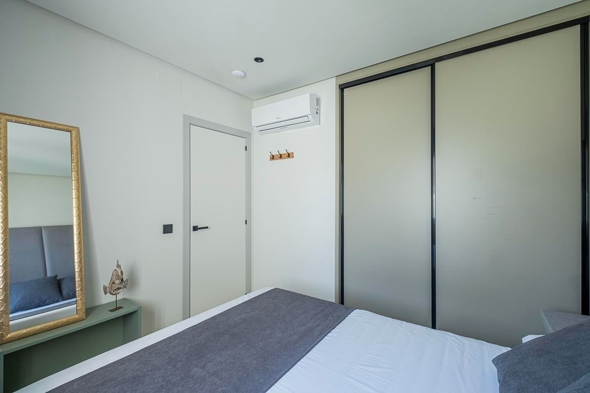 a bedroom with a bed a mirror and a sliding door