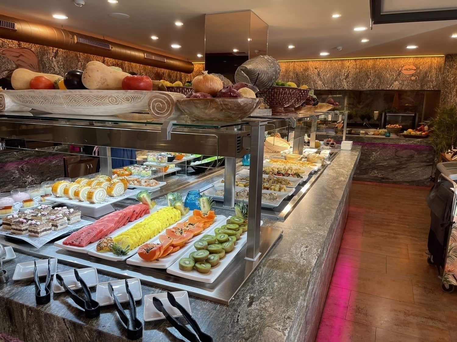 a buffet with a variety of fruits and desserts