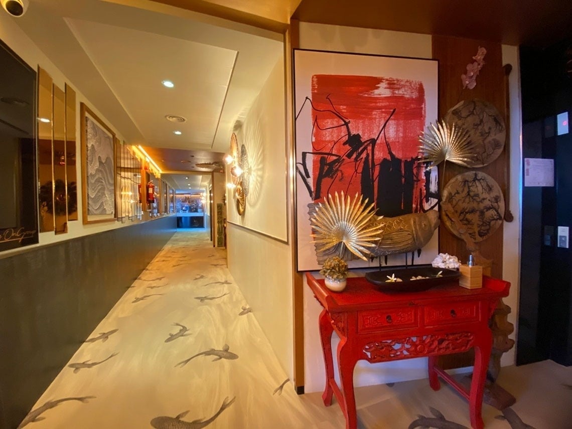 a hallway with a red table and a painting on the wall
