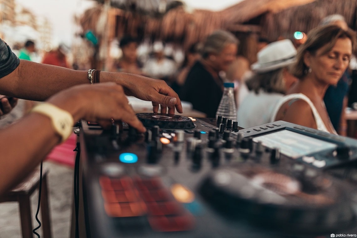un dj toca la música en una fiesta en la playa