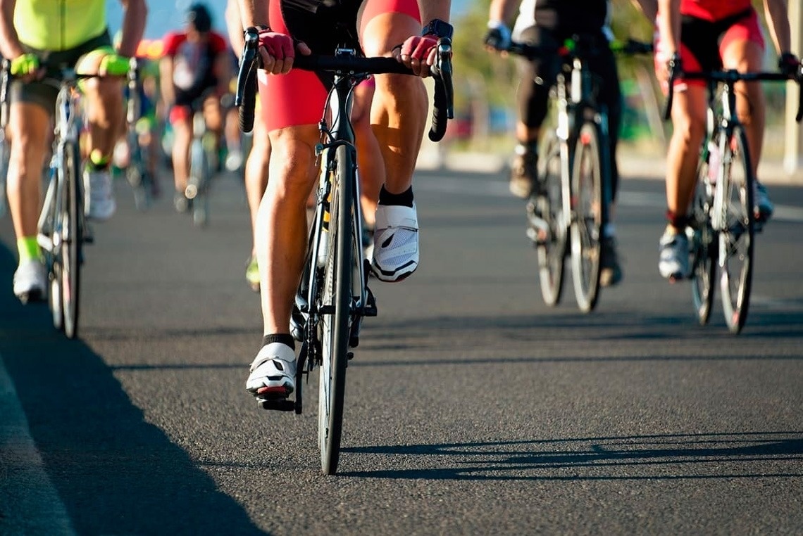 a group of people are riding bicycles down a road