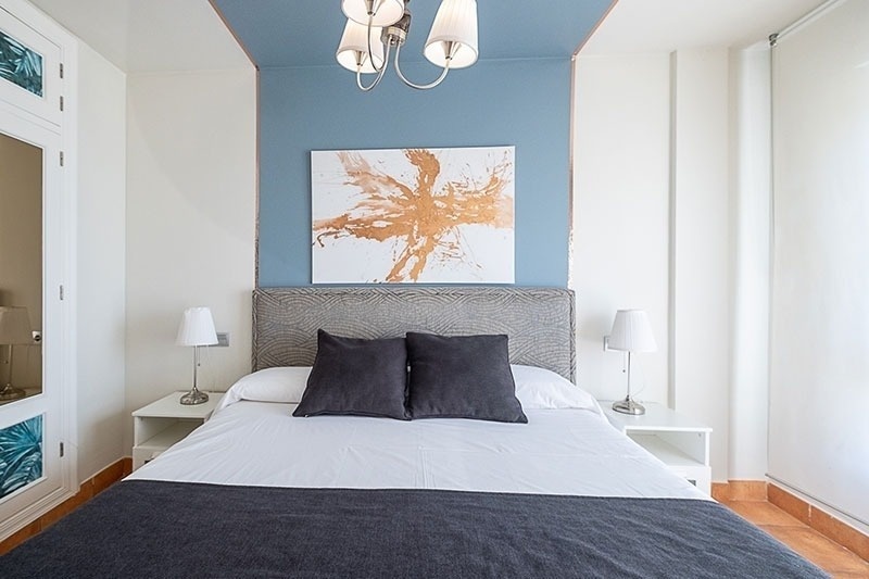 un dormitorio con una cama y una pintura en la pared