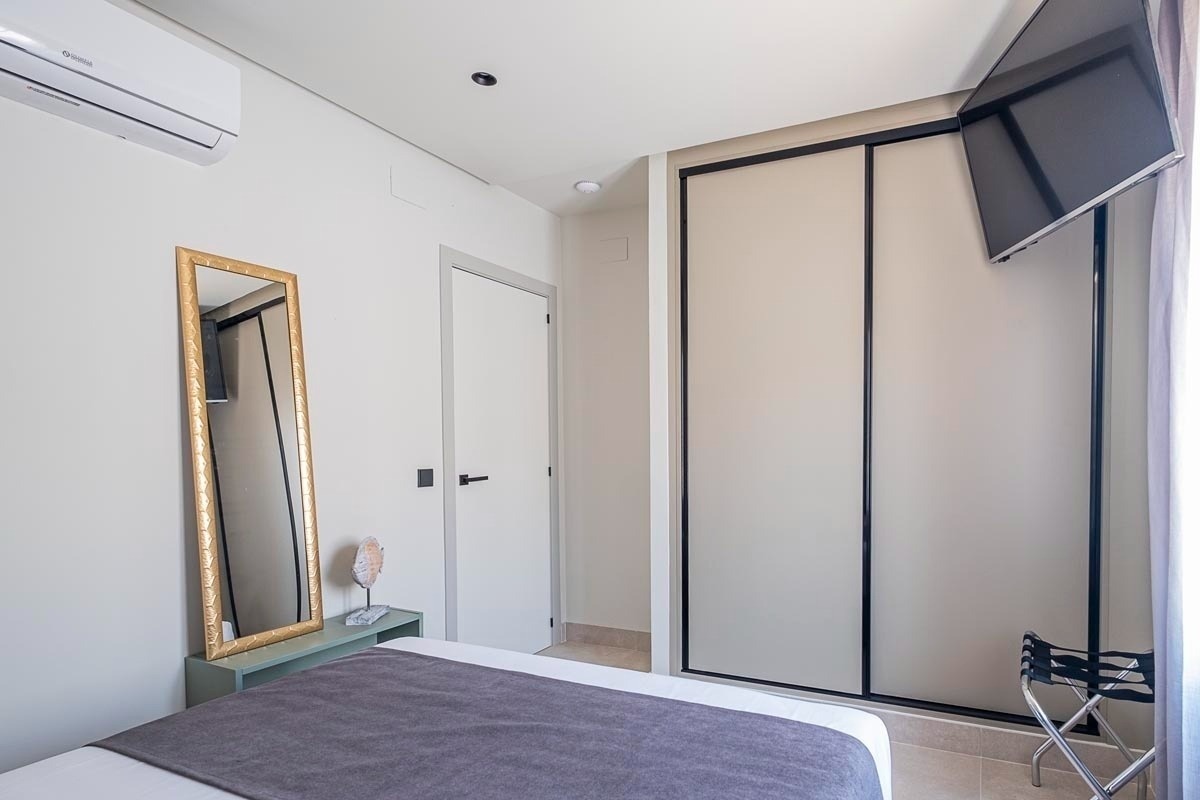 a bedroom with a large mirror and a samsung air conditioner