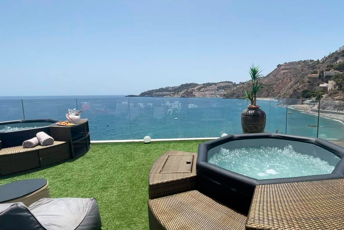 a hot tub on a balcony overlooking the ocean