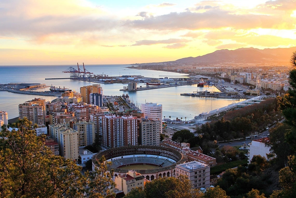 une vue aérienne d' une ville et d' un port au coucher du soleil