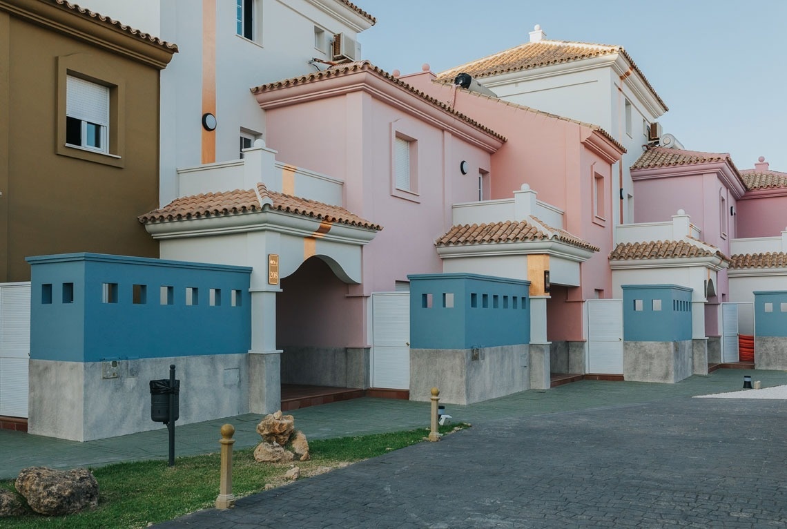 un edificio rosa y blanco con balcones y una puerta azul