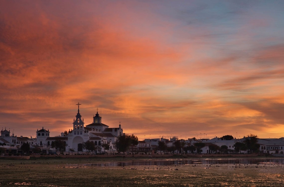 a sunset with a church in the foreground