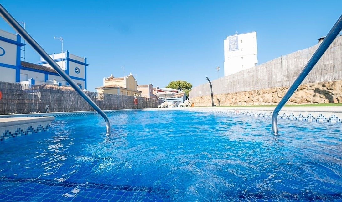 una piscina con un edificio blanco y azul en el fondo