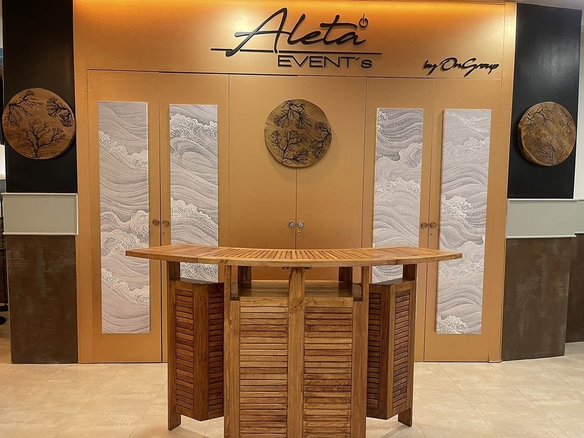 a wooden table in front of a aleta event 's sign
