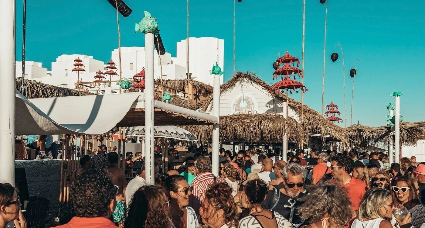 dos copas de champán con bebidas y sombrillas en la piscina