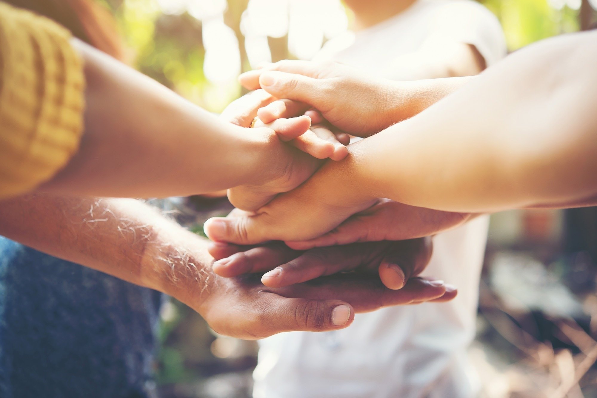 a group of people putting their hands together