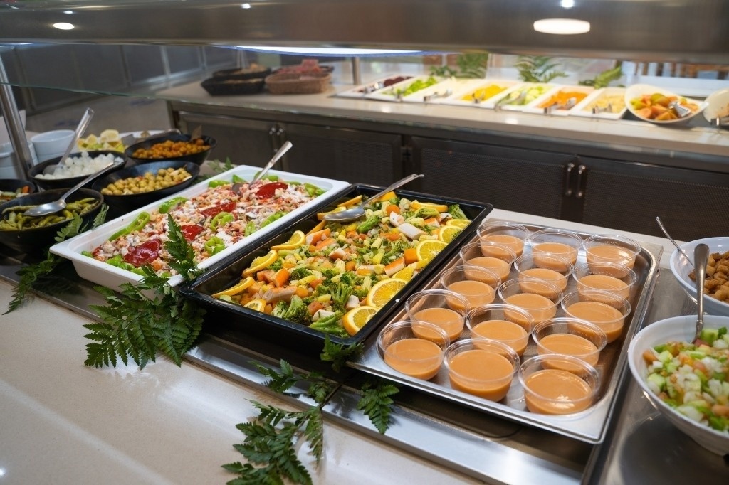 a buffet line with a variety of salads and sauces