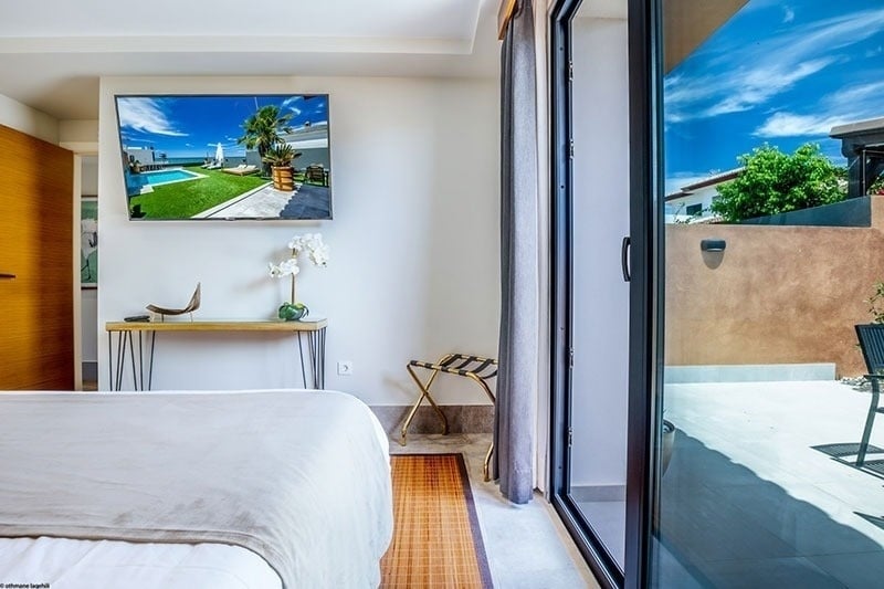 a bedroom with a large flat screen tv above the bed