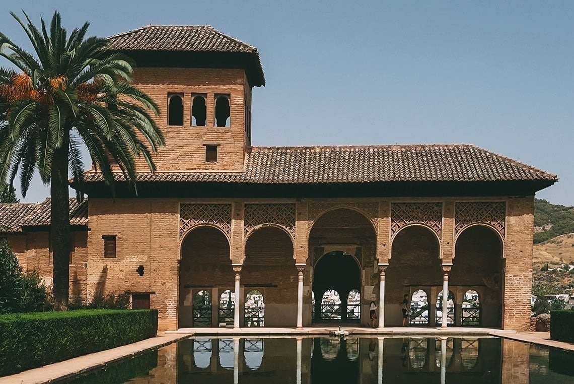 a building with arches and a pool in front of it