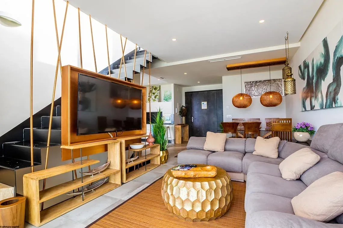 Sala de estar moderna con TV grande y muebles elegantes en ON Village Matalascañas.