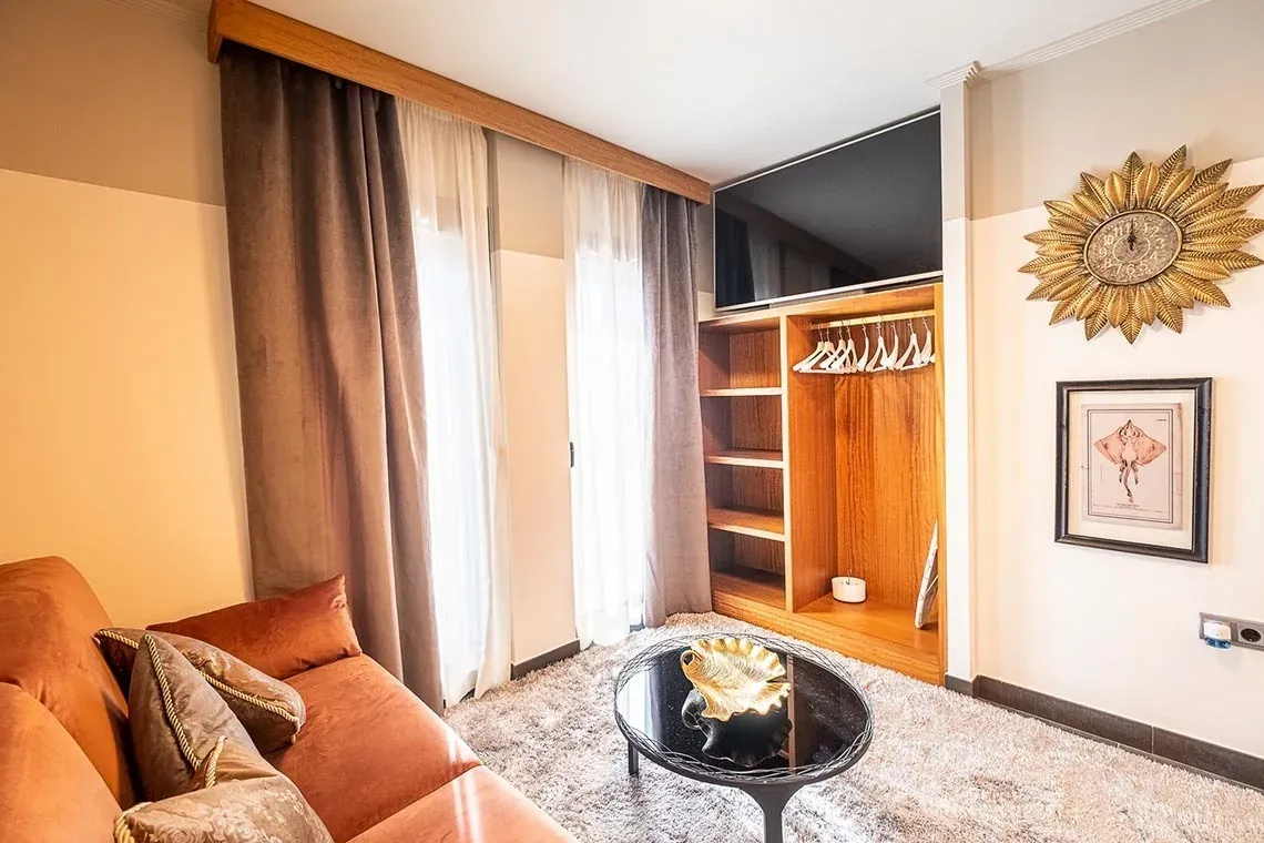 Habitación de lujo en ON Suites Sevilla con sofá, mesa de centro y decoración elegante.