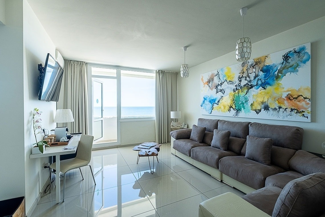 una sala de estar con un sofá y una pintura en la pared