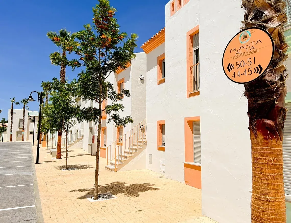 Apartamentos ON City en Doñana: acceso planta alta con carteles indicativos.