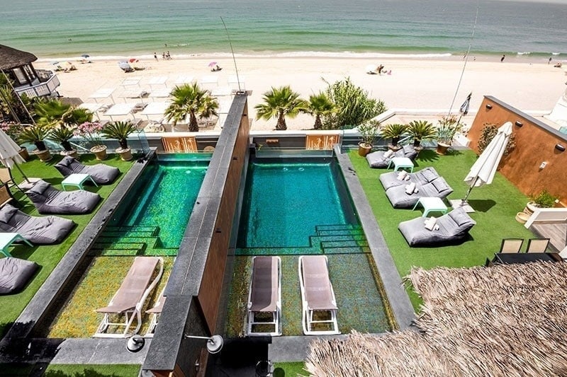 una vista aérea de una piscina junto a la playa