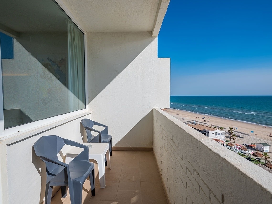 un balcón con dos sillas y una mesa con vista al océano