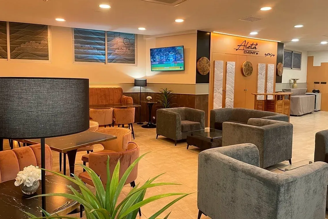 Salón moderno de ON Corporativa, con sofás grises y sillas naranjas.