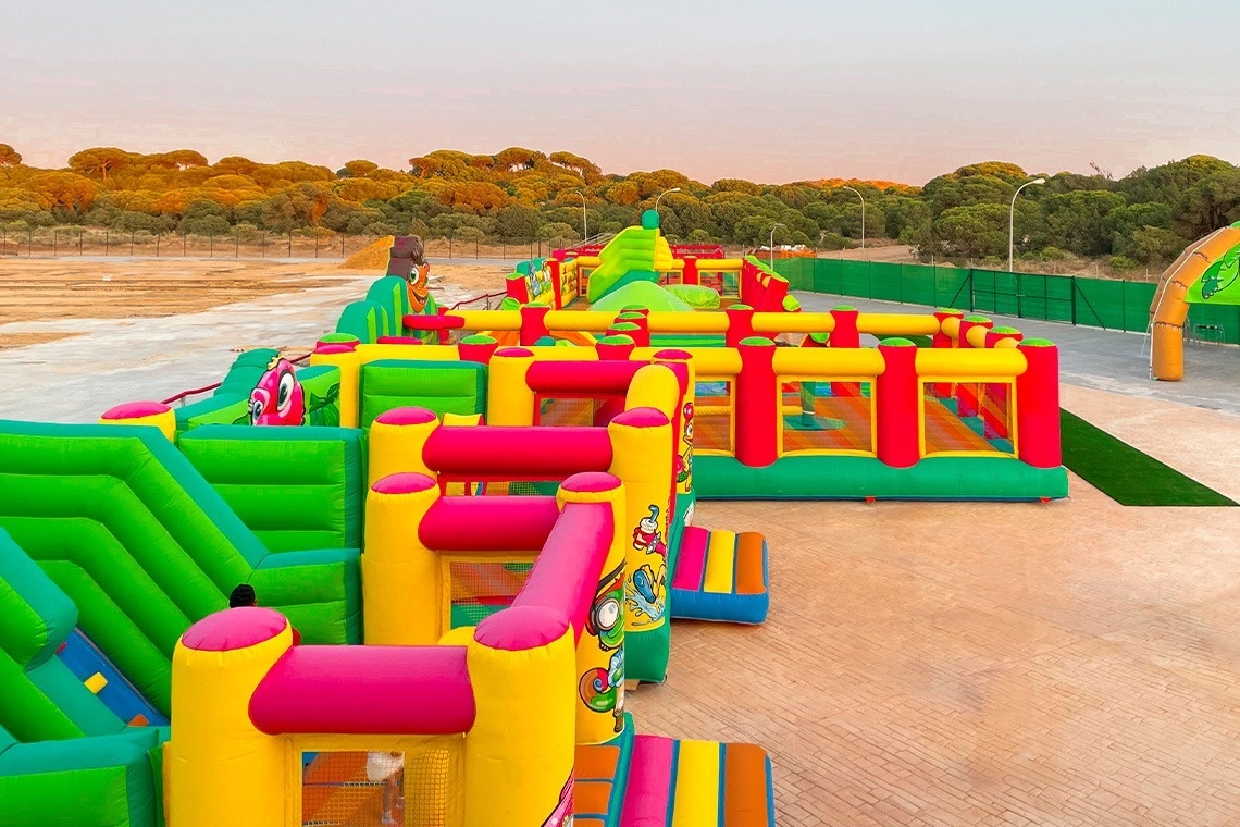 a bunch of colorful bouncy castles are lined up in a park
