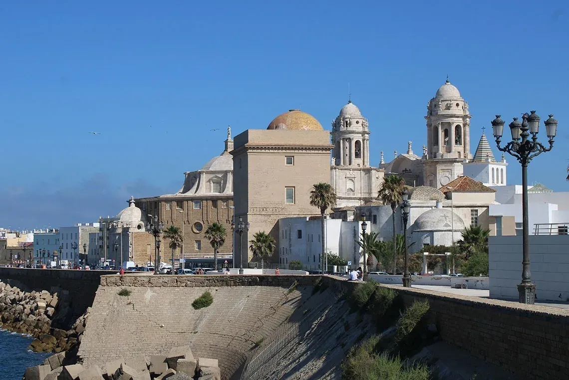 On Hotels: ON Corporativa. Catedral de Cádiz con cúpula dorada frente al mar.