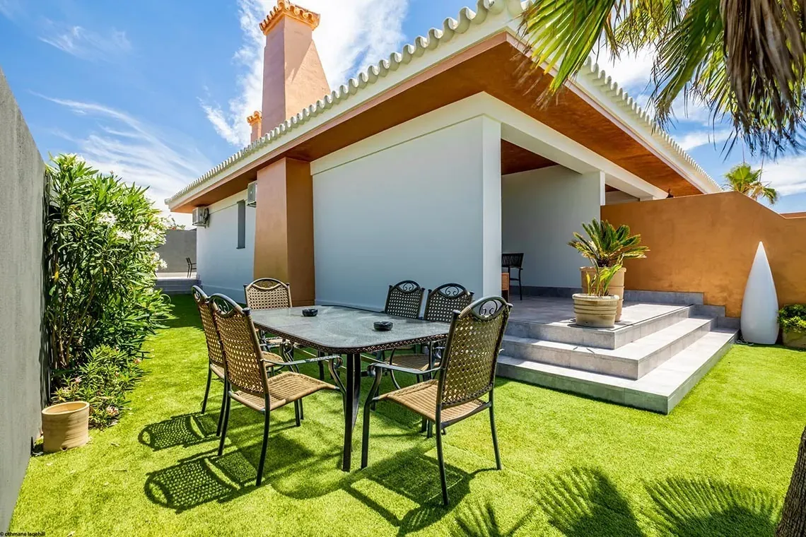 Comedor exterior para ON Village Matalascañas, villa privada ON Hotels, césped artificial.