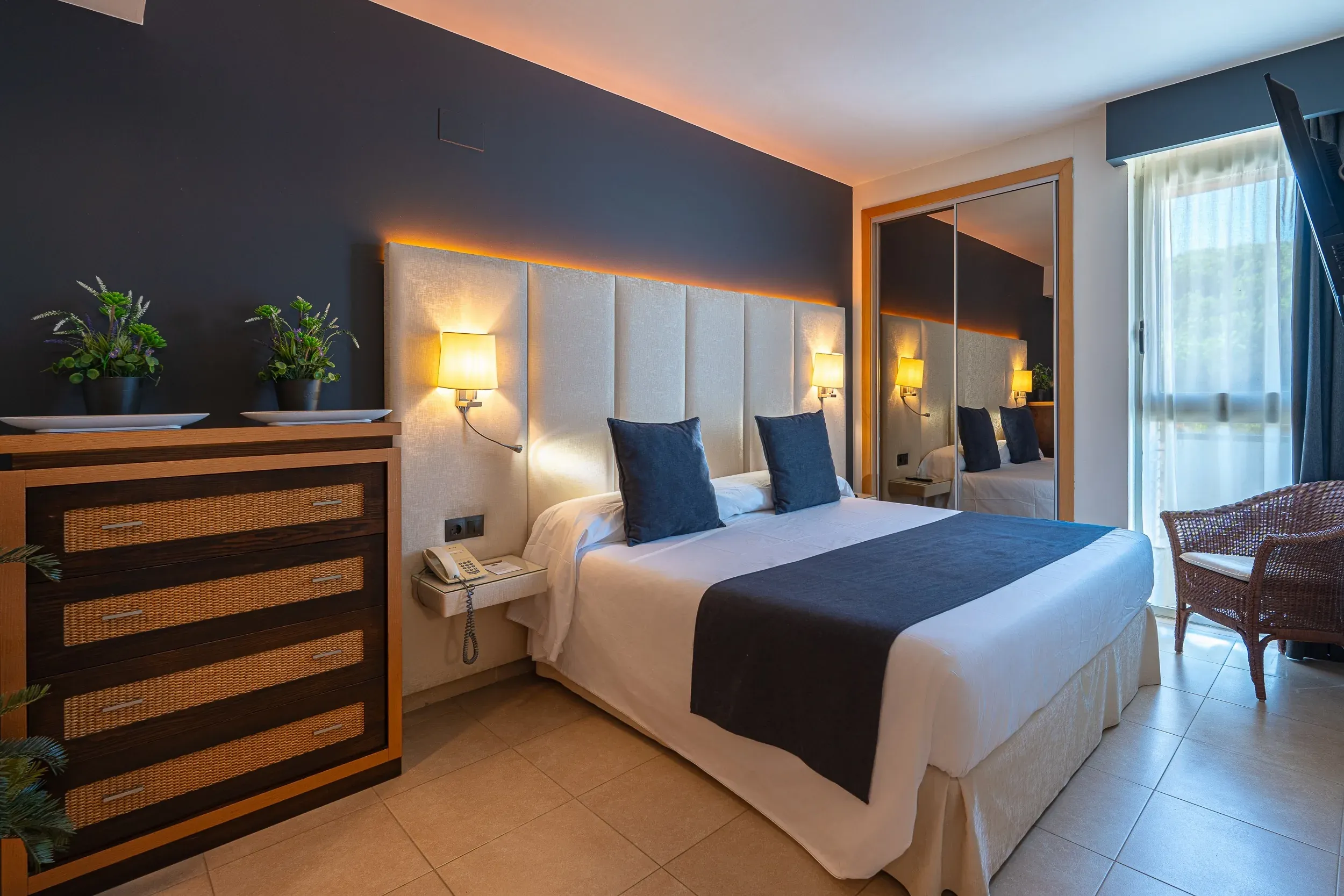 Habitación moderna con cama King Size, mesita de noche, armario y balcón. ON Family Islantilla Isla Cristina | Huelva