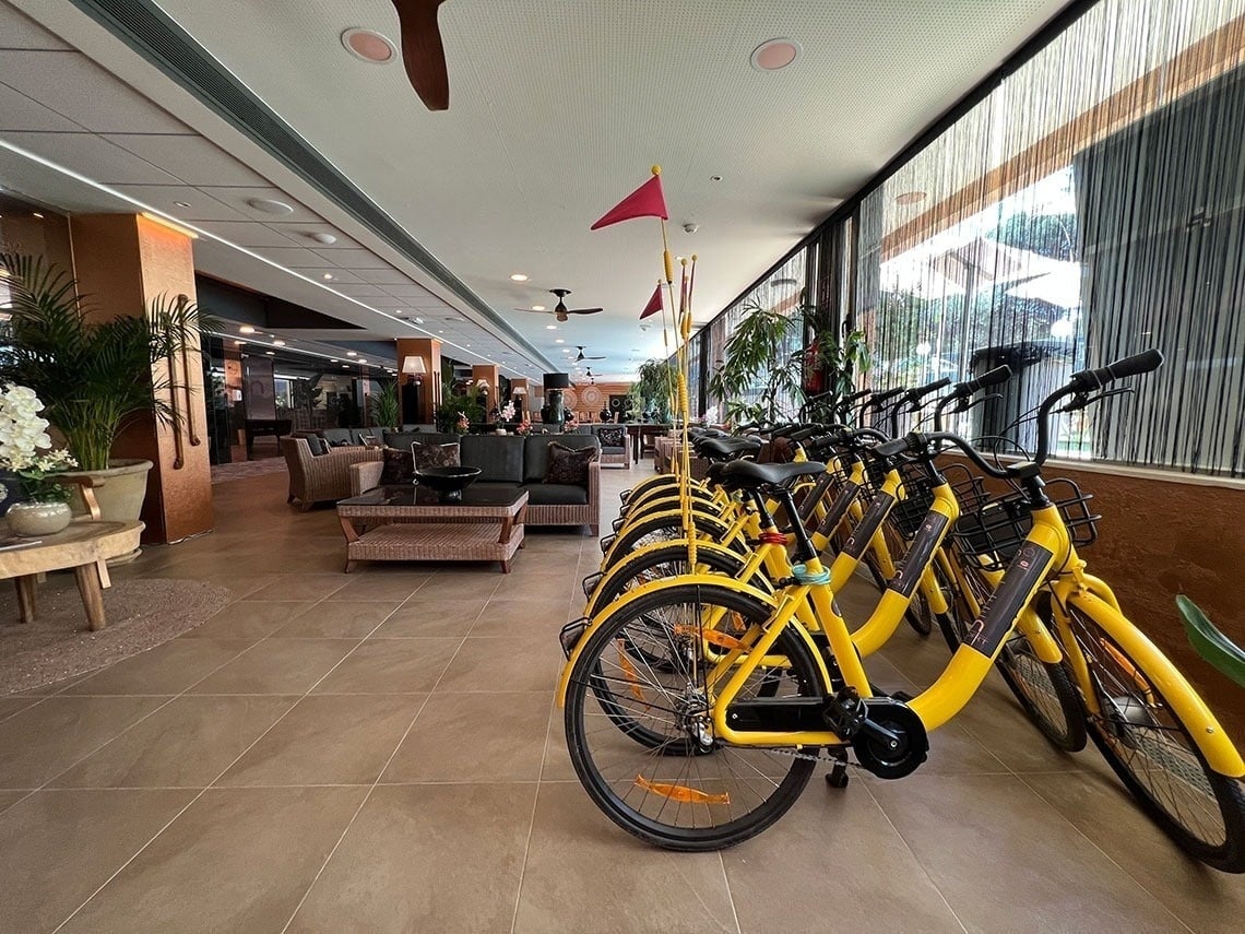 a row of yellow bikes are lined up in a room