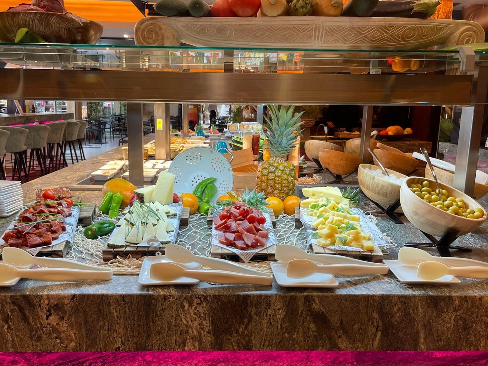 a buffet filled with fruits and vegetables including a pineapple