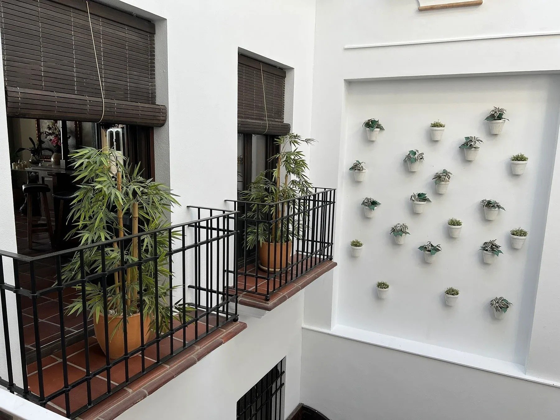 a balcony with potted plants and a wall of potted plants