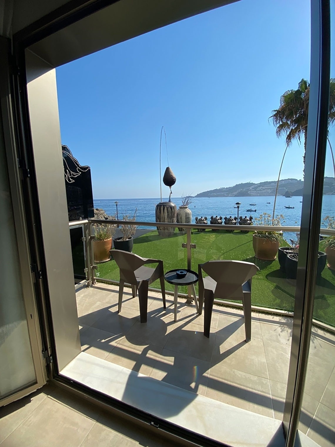 una vista del océano desde un balcón con sillas y una mesa