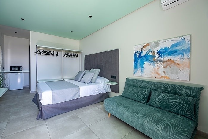 una habitación con una cama y un sofá y una pintura en la pared