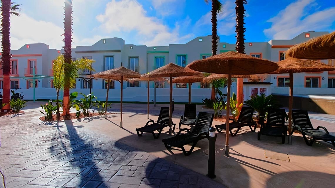 a row of chairs and umbrellas in front of a building