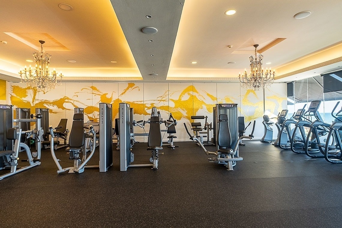 un gimnasio con muchos aparatos y una pared amarilla