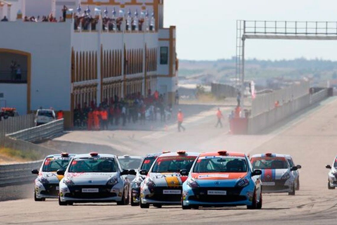 um grupo de carros de corrida está dirigindo em uma pista de corrida .