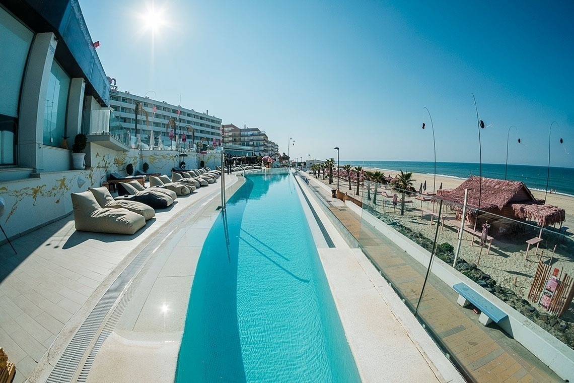 una gran piscina junto a la playa en un día soleado