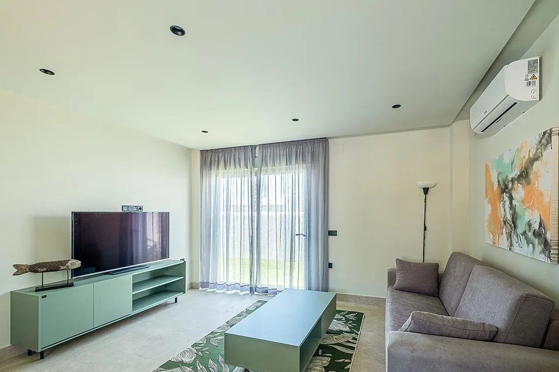 Salón moderno con sofá, TV y arte abstracto en ON City Apartments, cerca del Parque Nacional de Doñana, On Hotels.