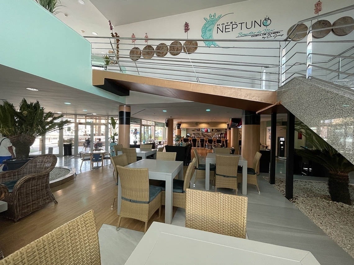 a restaurant with tables and chairs and the word neptune on the wall