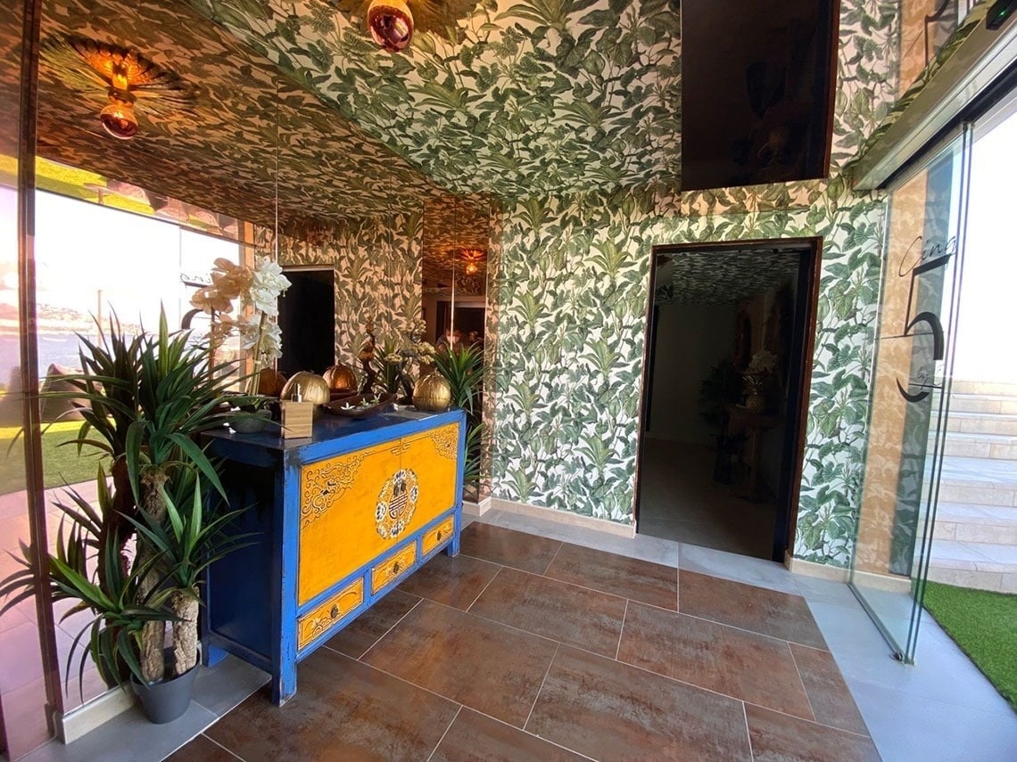una puerta de vidrio conduce a una habitación con un mueble azul y amarillo