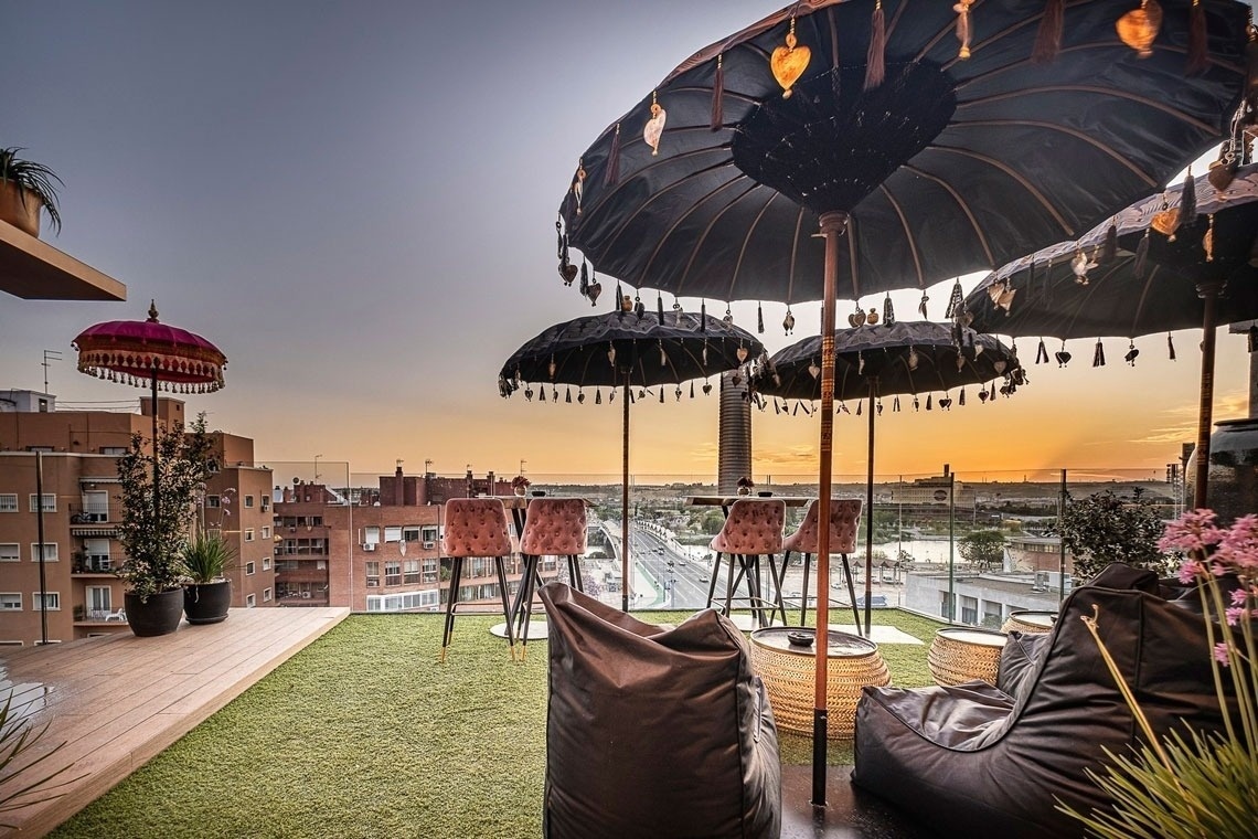 a rooftop patio with umbrellas and bean bag chairs
