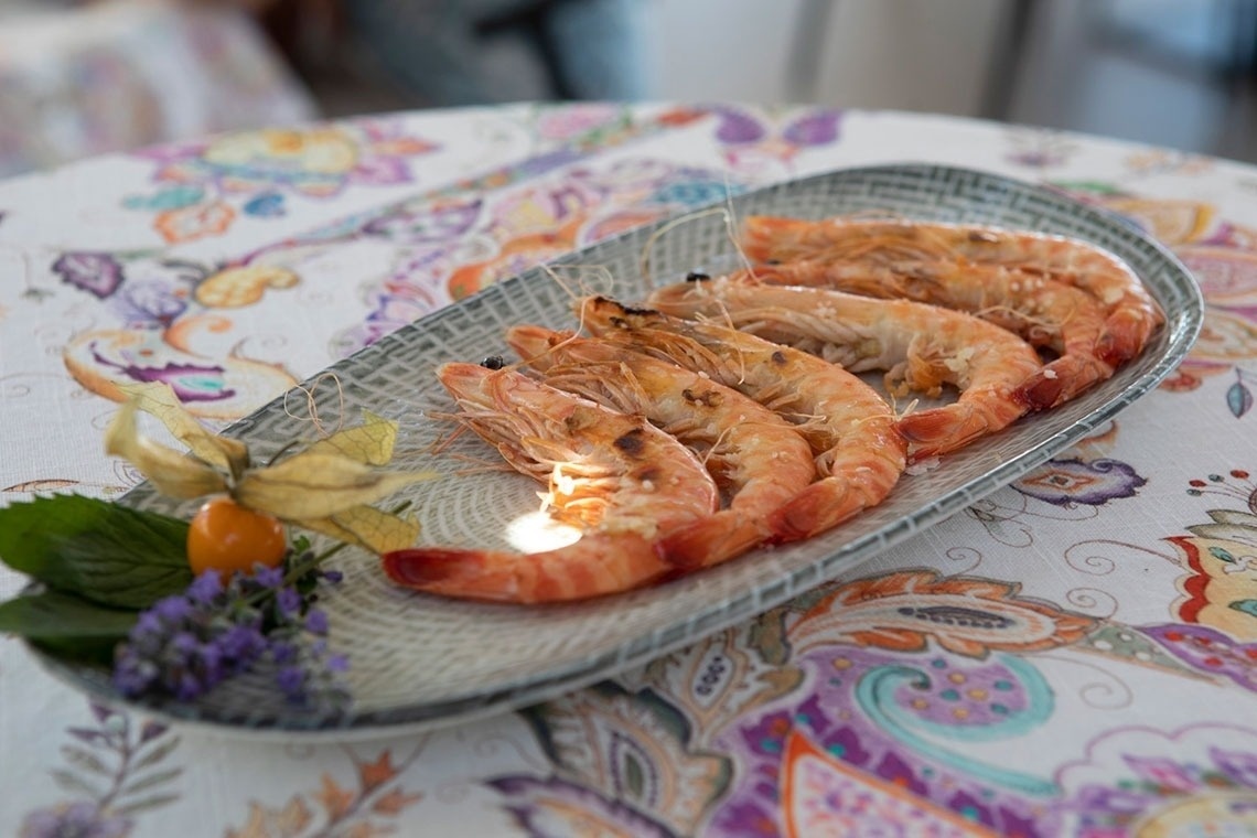 a plate of shrimp sits on a table cloth