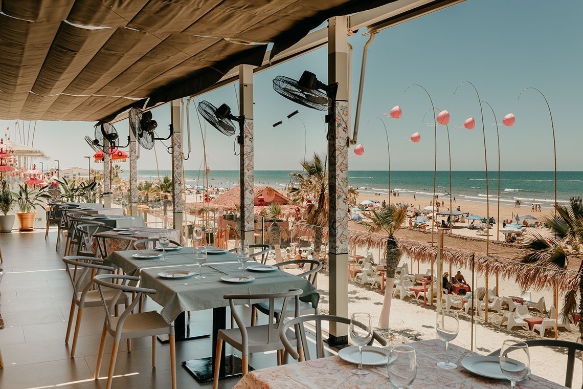 a restaurant with tables and chairs and a sign that says ' aloha ' on it